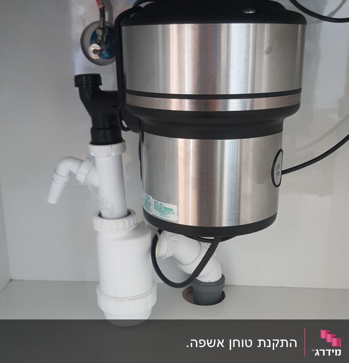 מתקן טוחן אשפה מתחת לכיור עם צינורות חיבור